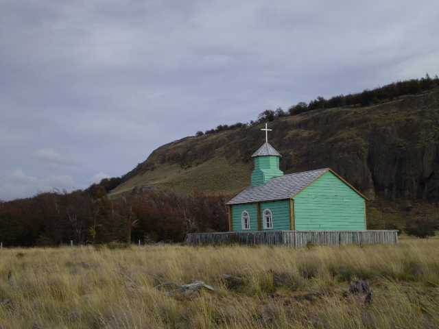 a little church sitting in the middle of a field