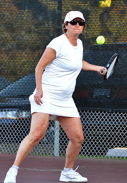 a woman hitting a tennis ball with a racquet