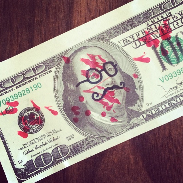 a po with a mustache and glasses painted on the dollar bill