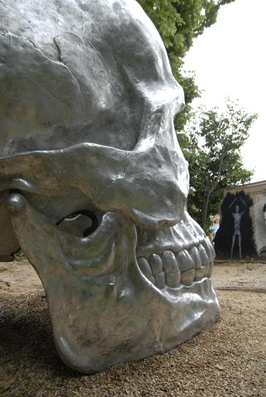 a statue of a silver human skull has been placed in front of the building