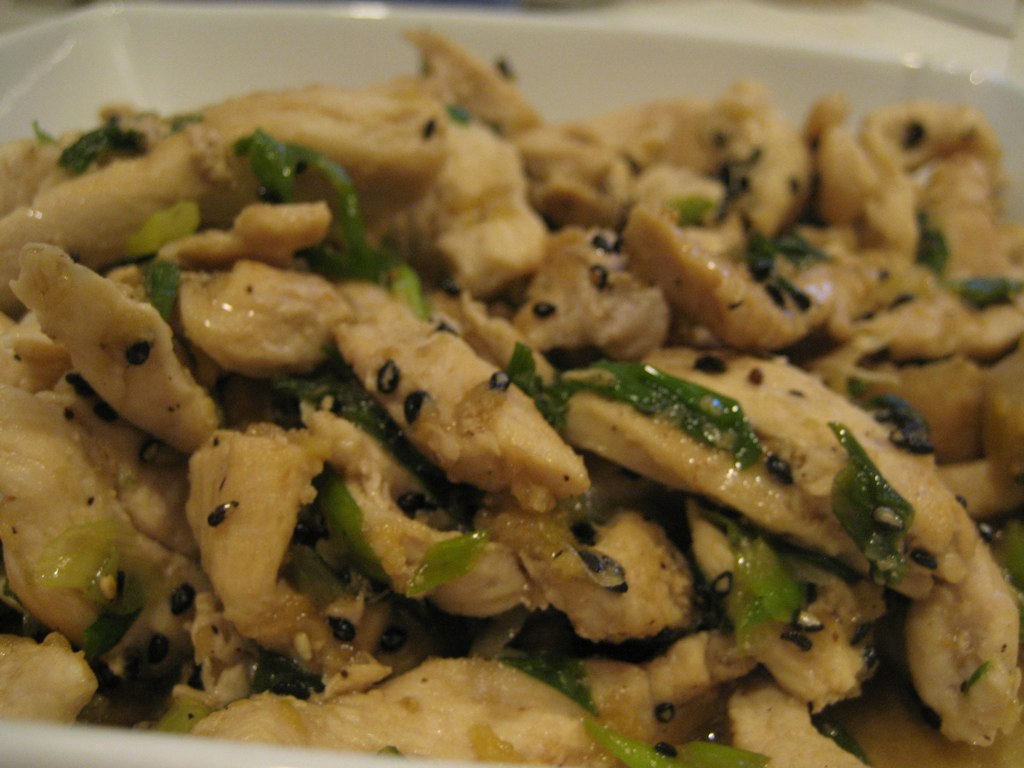 chicken with green peppers and sesame seeds in a serving dish