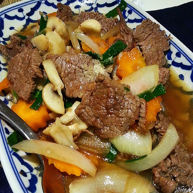 a plate with meat and vegetables in broth