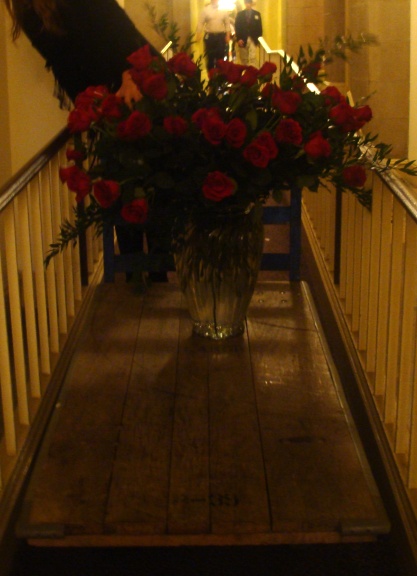 flowers are in a vase on the front railing