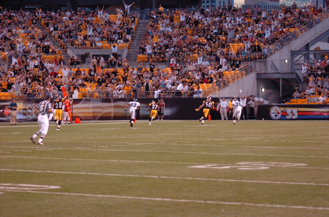 a football player running across the field to catch a ball