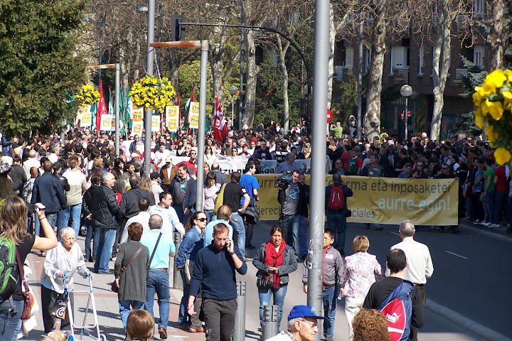 a large crowd of people walking down the street with signs