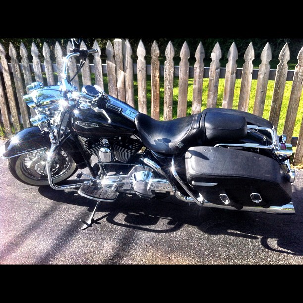 a black motorcycle is parked by the fence