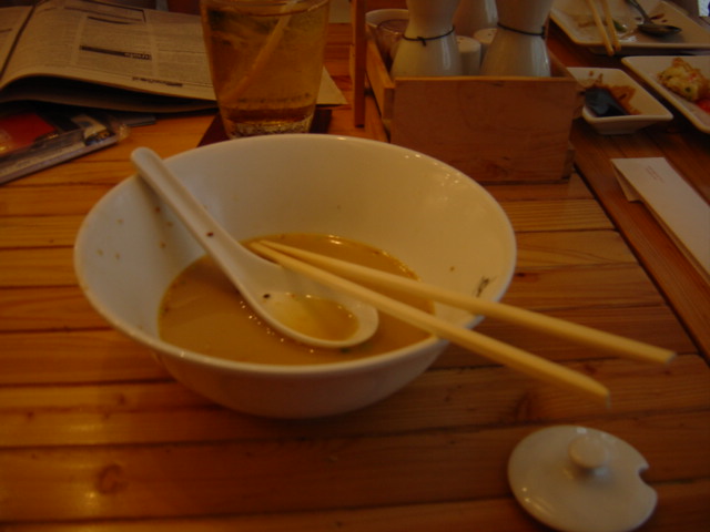 a bowl of soup with chopsticks sitting on the side
