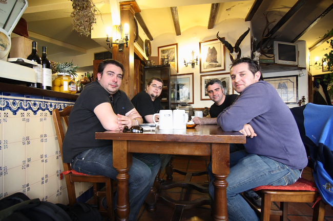 three men sitting at a wooden table at the restaurant