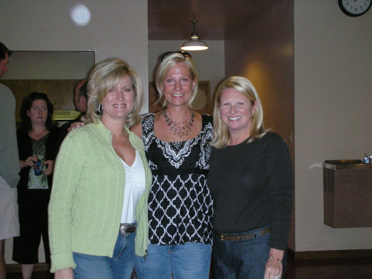 a group of three ladies standing in a hallway