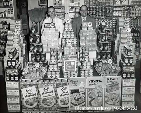 two men standing in front of a variety of foods
