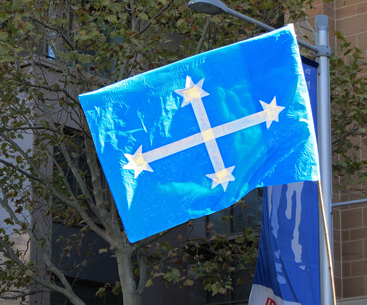 two flags with crosses on them that have been attached to trees