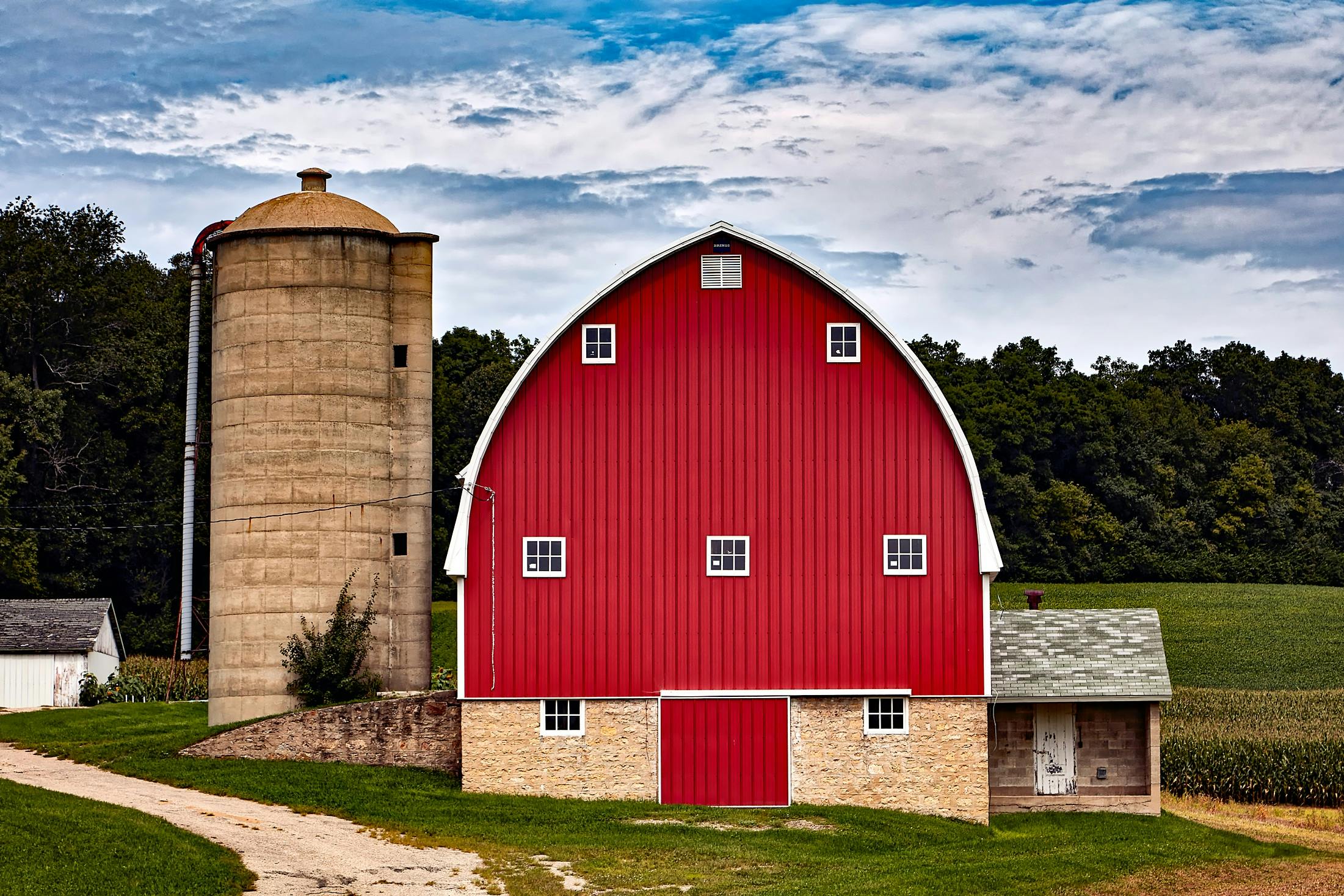 a red barn sitting on top of a lush green field, by Robert Storm Petersen, pexels contest winner, renaissance, silo, 2 5 6 x 2 5 6 pixels, wisconsin, panoramic