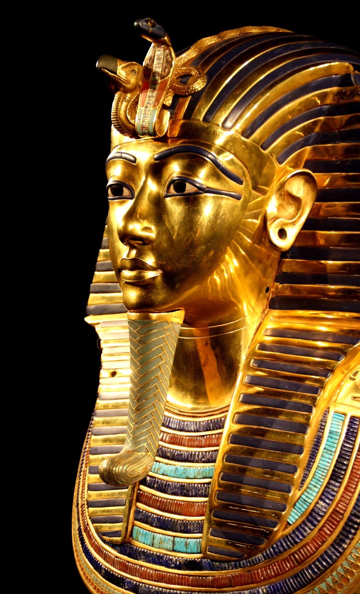 a close up of a gold mask on a black background, egyptian art, by Everett Warner, pexels, hurufiyya, extremely detailed frontal angle, tombs, a colorful, photographed for reuters