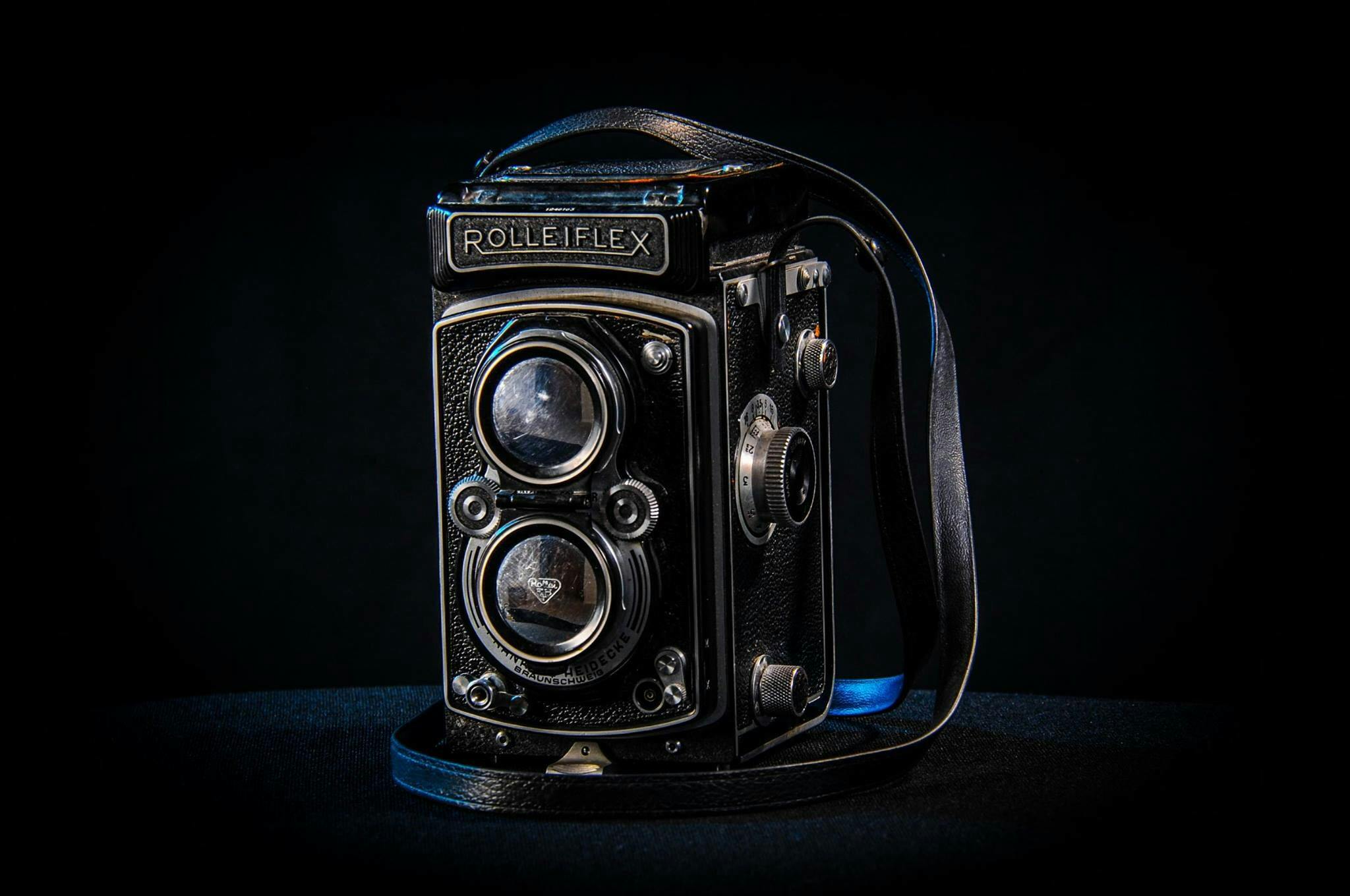 a close up of a camera on a table, rolleiflex, with a black background, portrait n - 9, medium