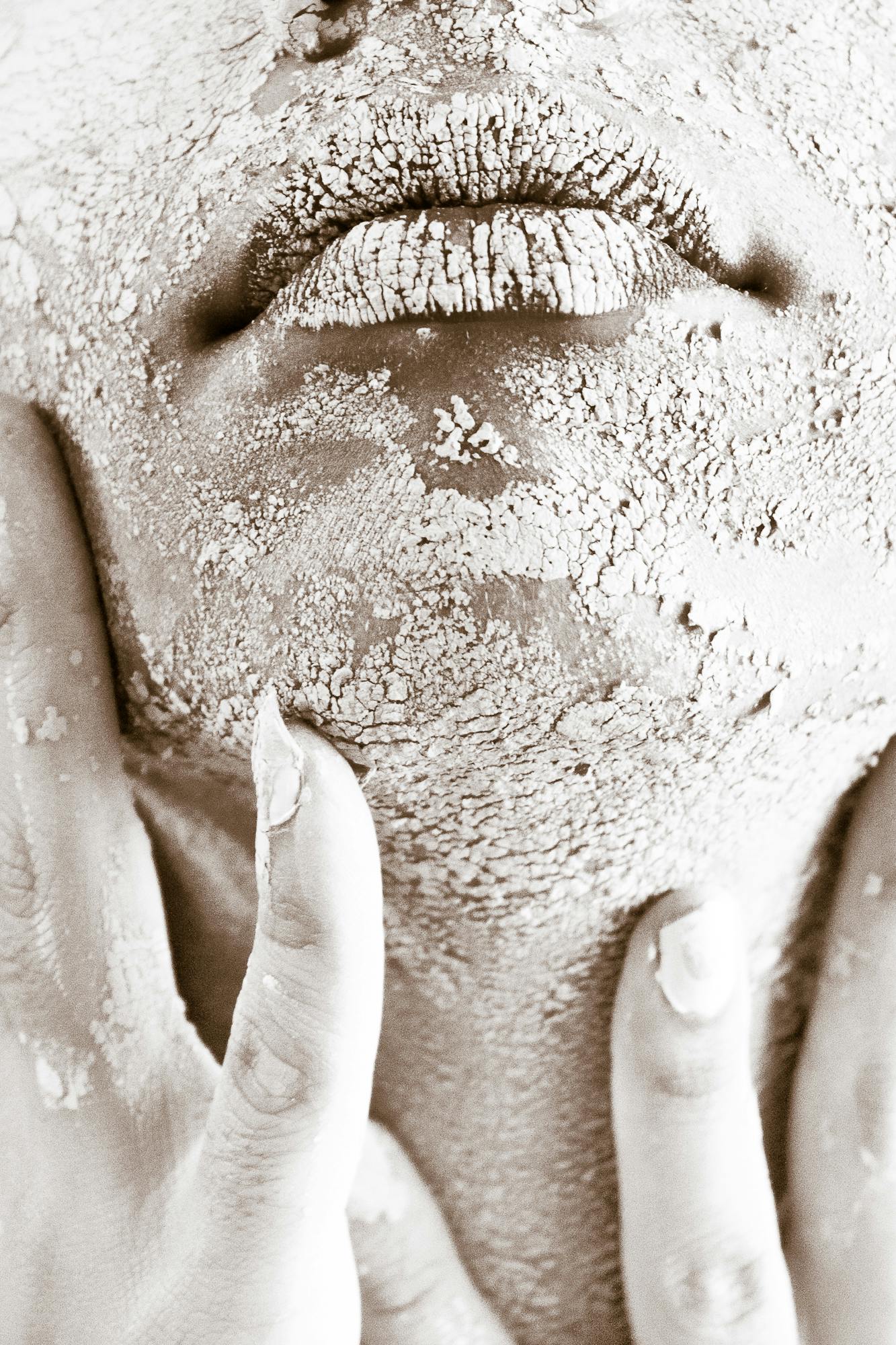 a close up of a person with mud on their face, a black and white photo, trending on pexels, renaissance, covered in white flour, gently caressing earth, dry brushing, facial hair