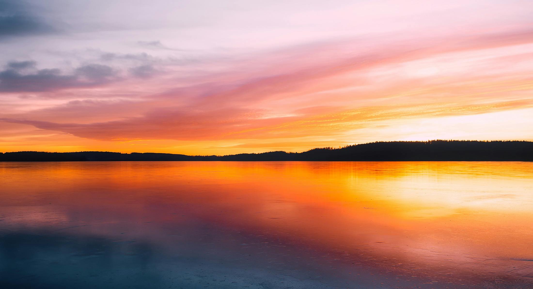 a large body of water with a sunset in the background, by Jaakko Mattila, pexels contest winner, brightly colored, lakeside, crisp colors, instagram post