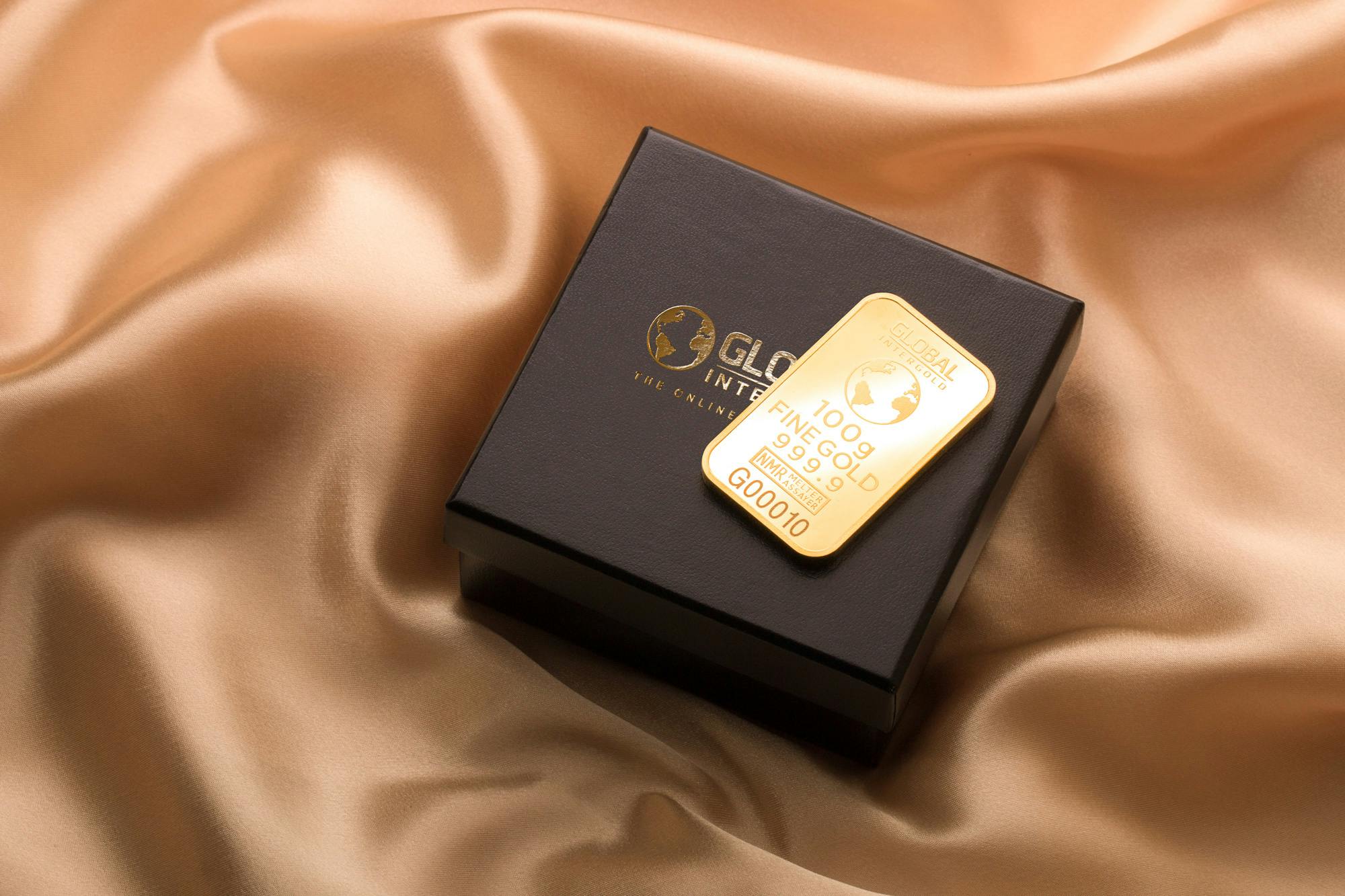 a gold bar sitting on top of a black box, inspired by Hedi Xandt, pexels contest winner, label, product display photograph, wealthy women, uk