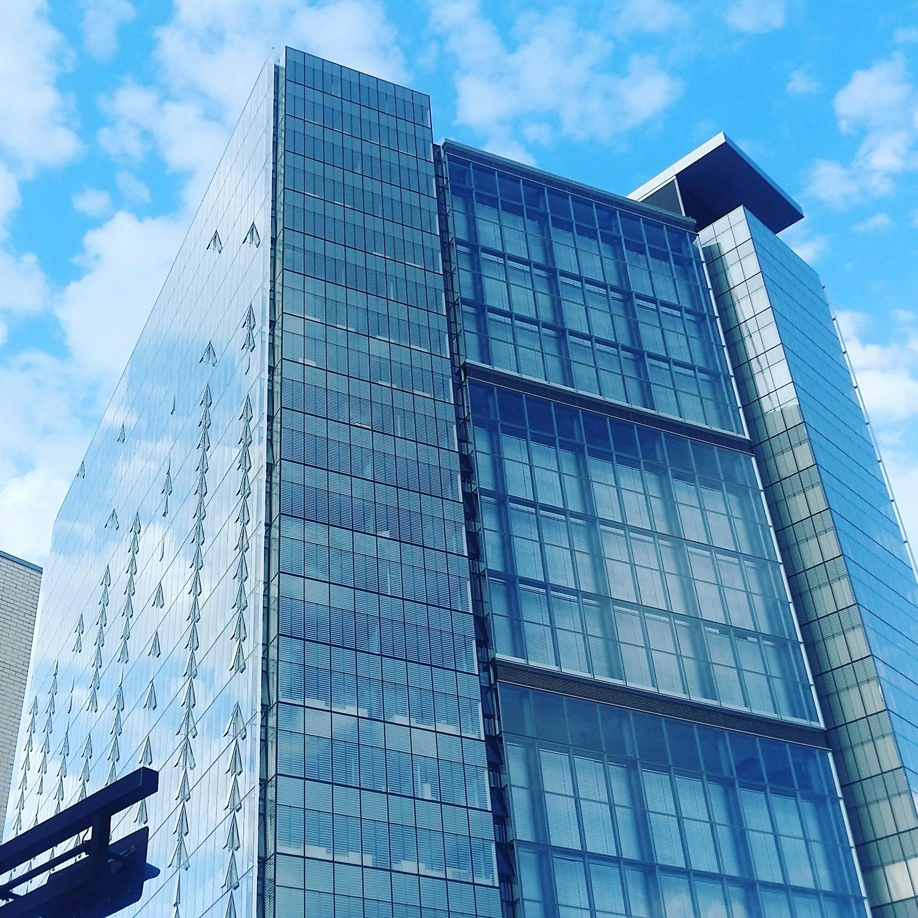 a very tall building with a lot of windows, a photo, unsplash, modernism, partly cloudy day, square enix, sharp foccus ilustration hq, clear blue skies