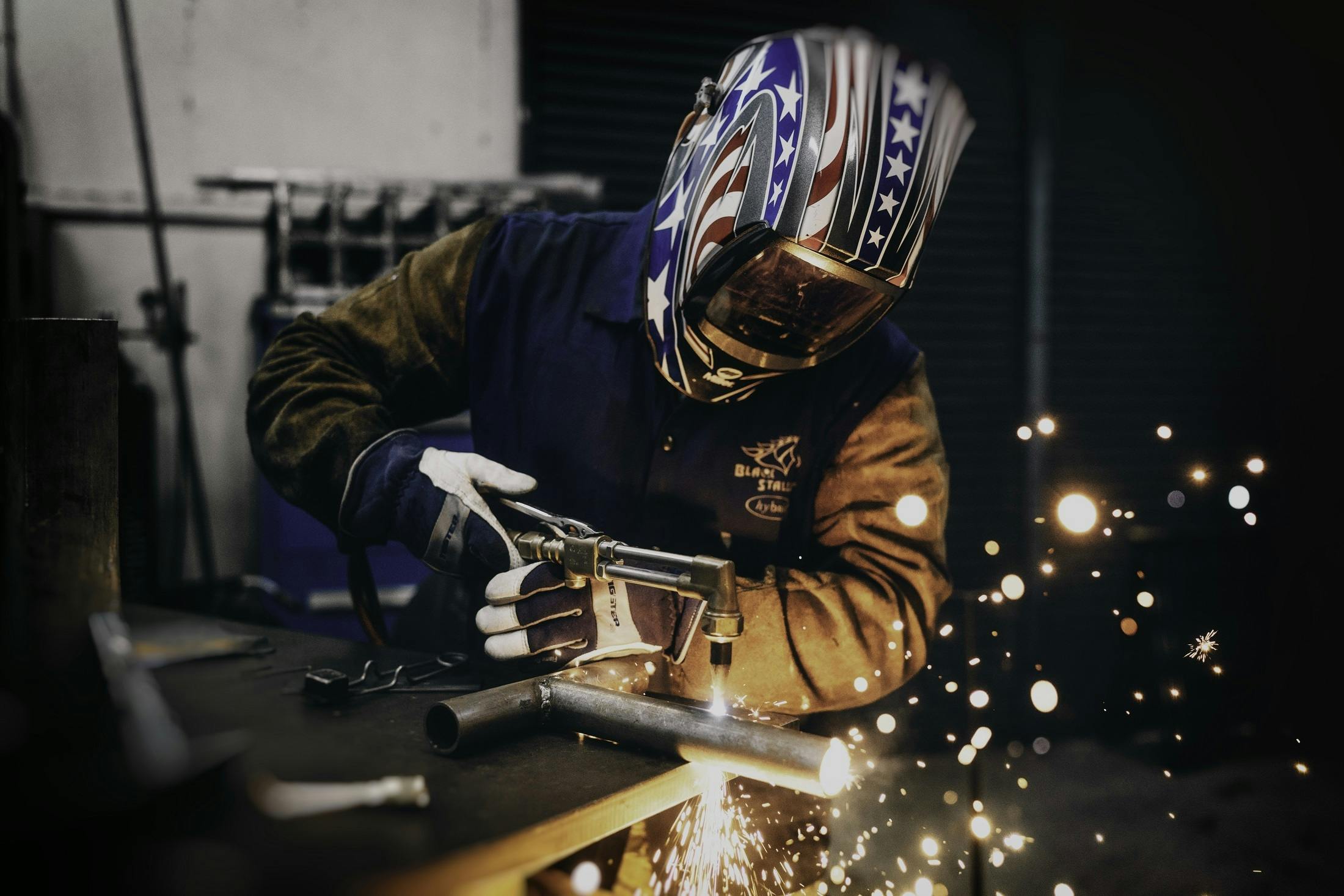a welder working on a piece of metal, a portrait, by Thomas Furlong, pexels contest winner, 9 9 designs, worksafe. instagram photo, patriotism, professional gunsmithing