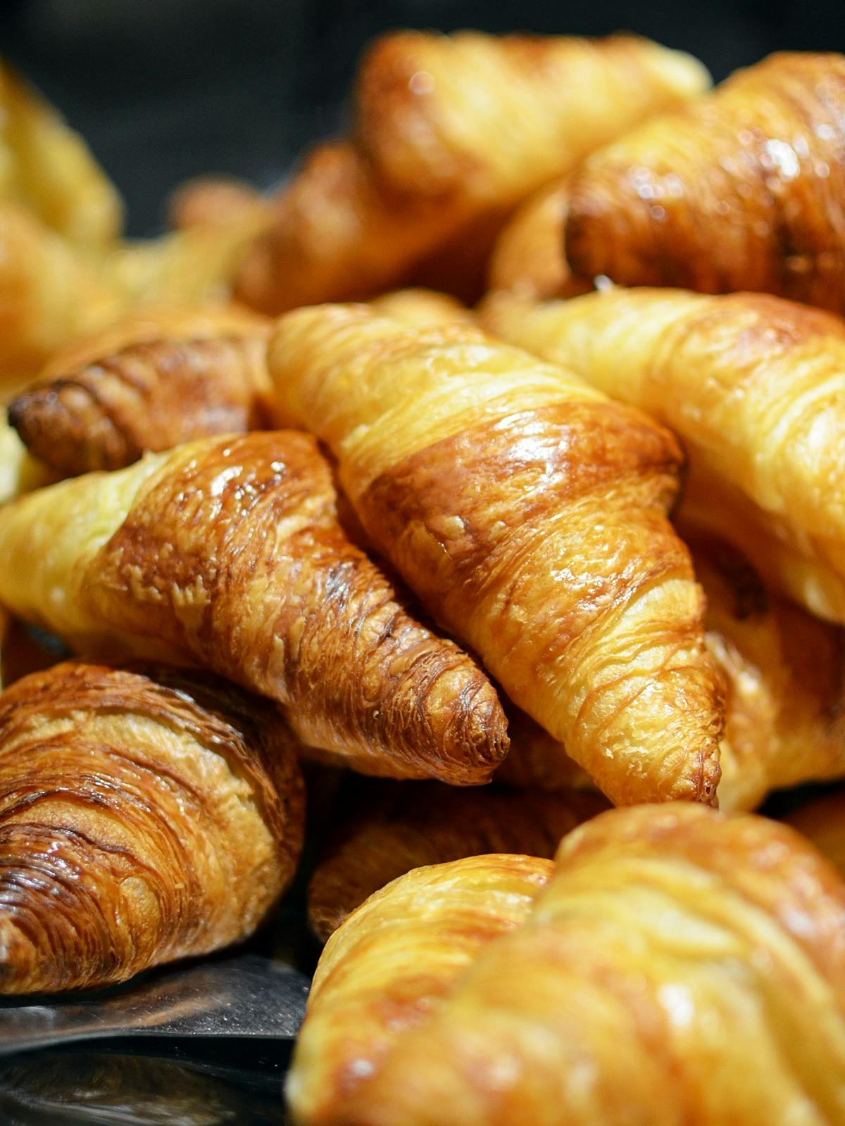 a pile of croissants sitting on top of a table, touring, profile image