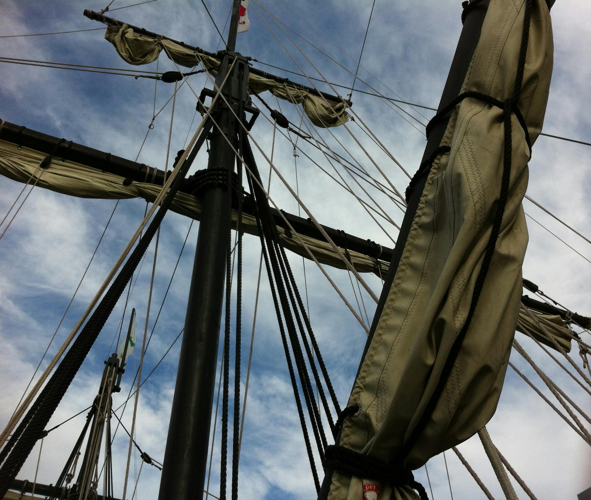 a close up of a sail on a body of water, renaissance, looking up onto the sky, docked at harbor, pirate clothing, phone photo