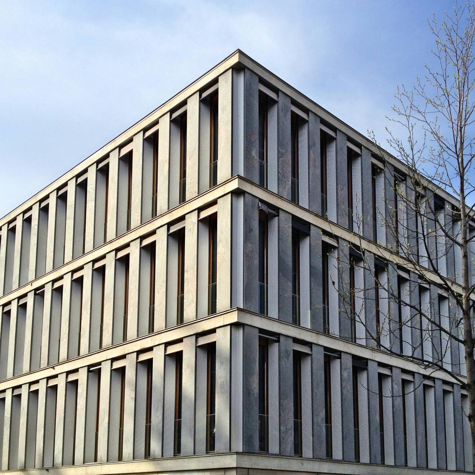 a very tall building with lots of windows, inspired by David Chipperfield, brutalism, weathered concrete, government archive photograph, detmold charles maurice, neoclassical police station