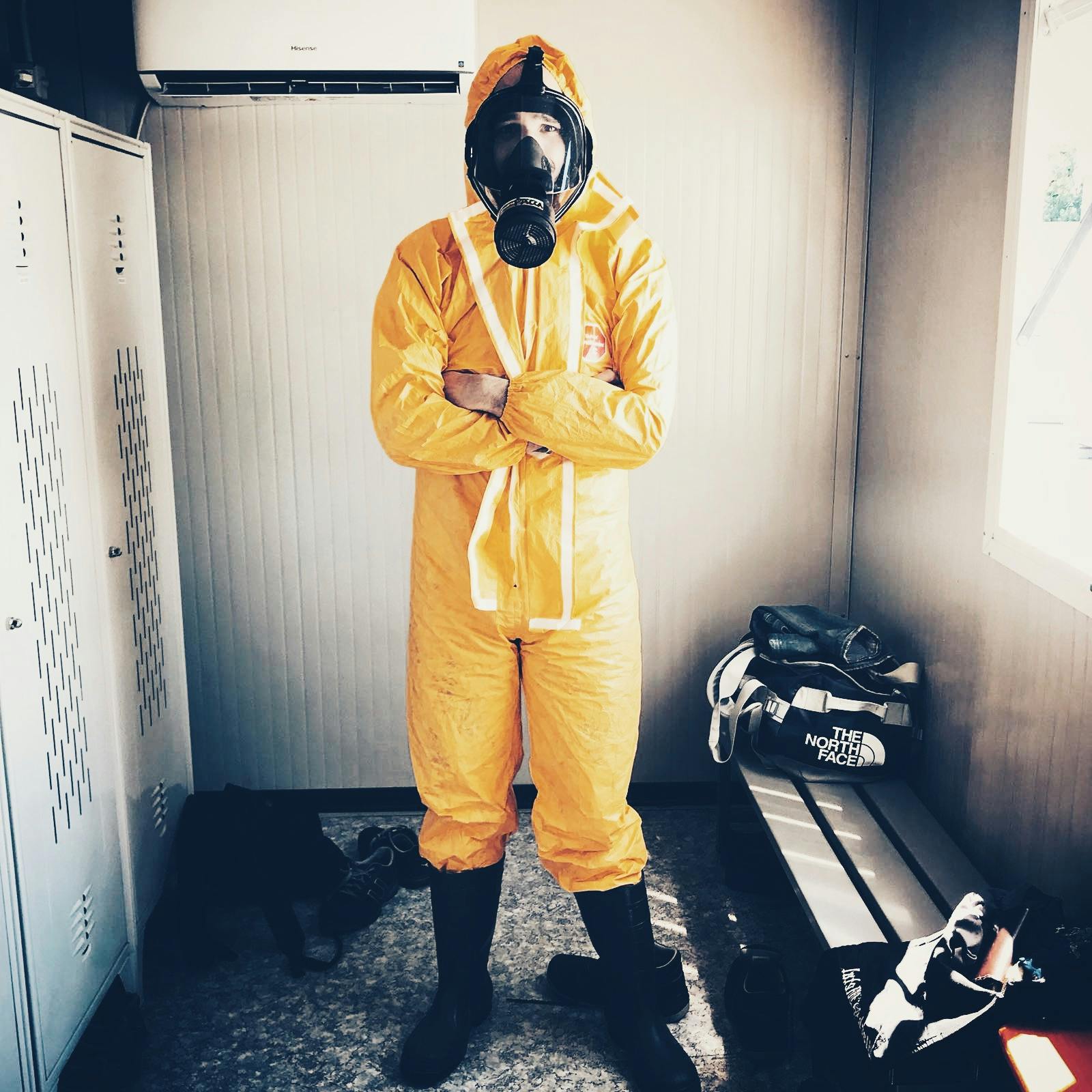 a man in a yellow hazmat suit standing in a room, a picture, pexels contest winner, wearing dirty travelling clothes, black rubber suit, ((rust)), full body with costume