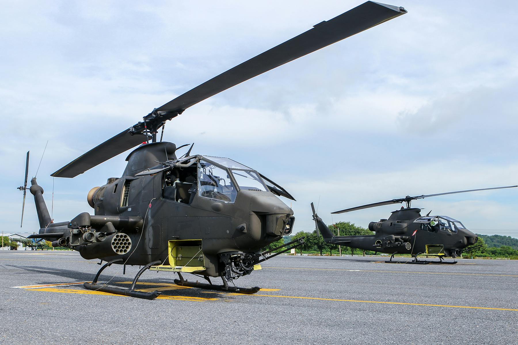 a couple of black helicopters sitting on top of a tarmac, a portrait, hurufiyya, avatar image, malaysian, high-resolution photo