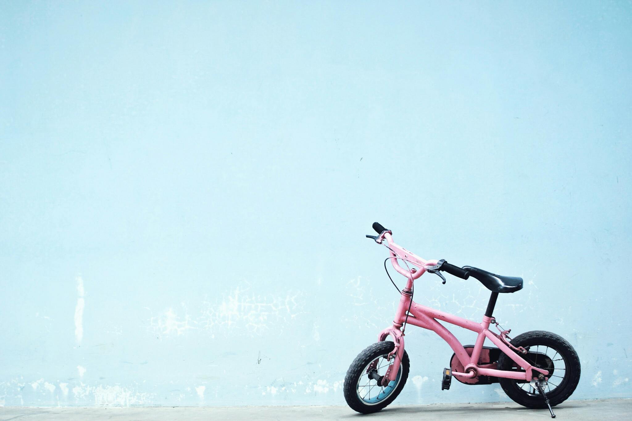 a pink bike leaning against a blue wall, pexels contest winner, little kid, modified, pink and black, hyperdetailed