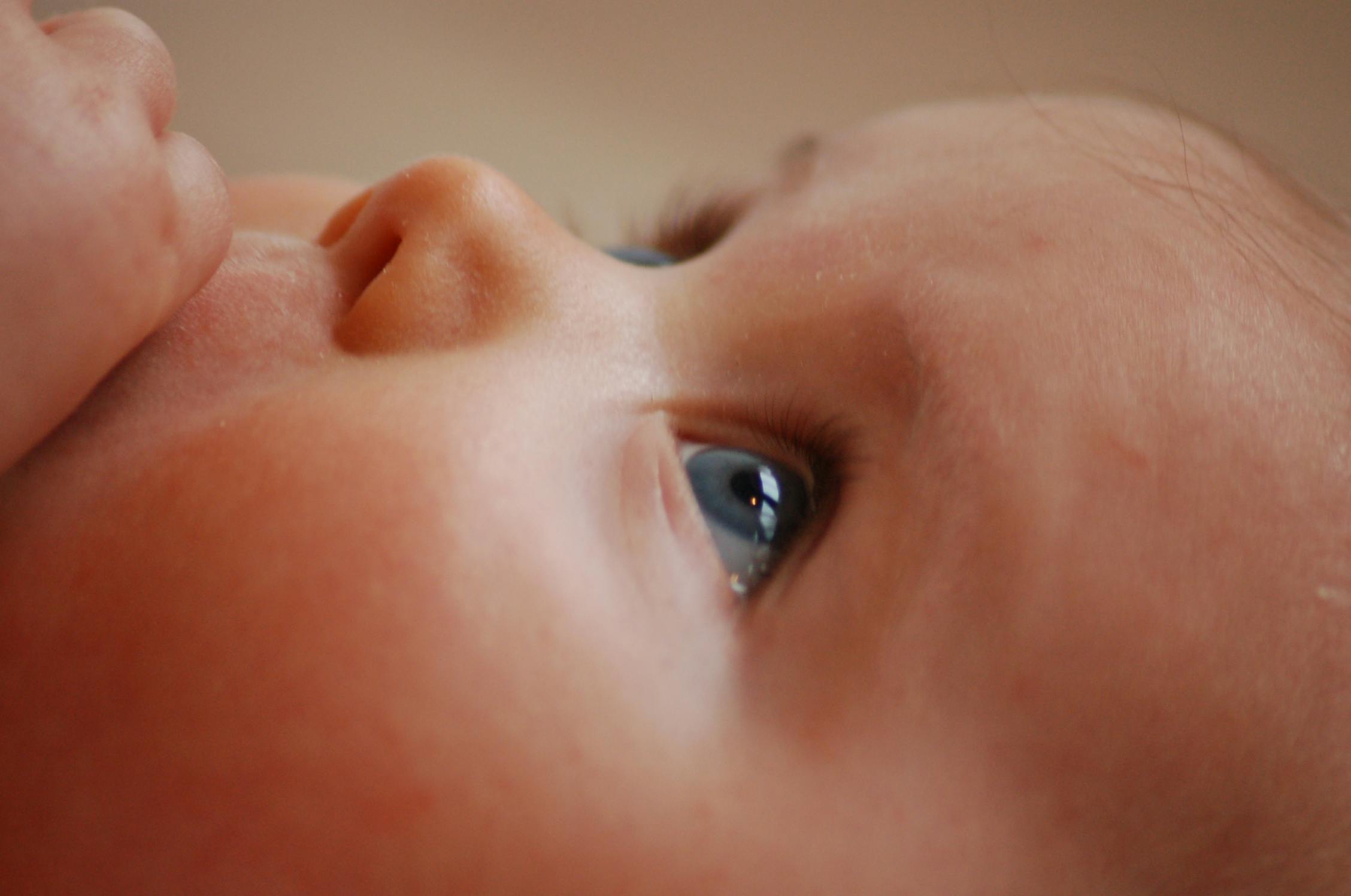 a close up of a baby drinking from a bottle, pexels contest winner, hyperrealism, light grey-blue eyes, close - up profile face, perfectly shaded face, looking from slightly below
