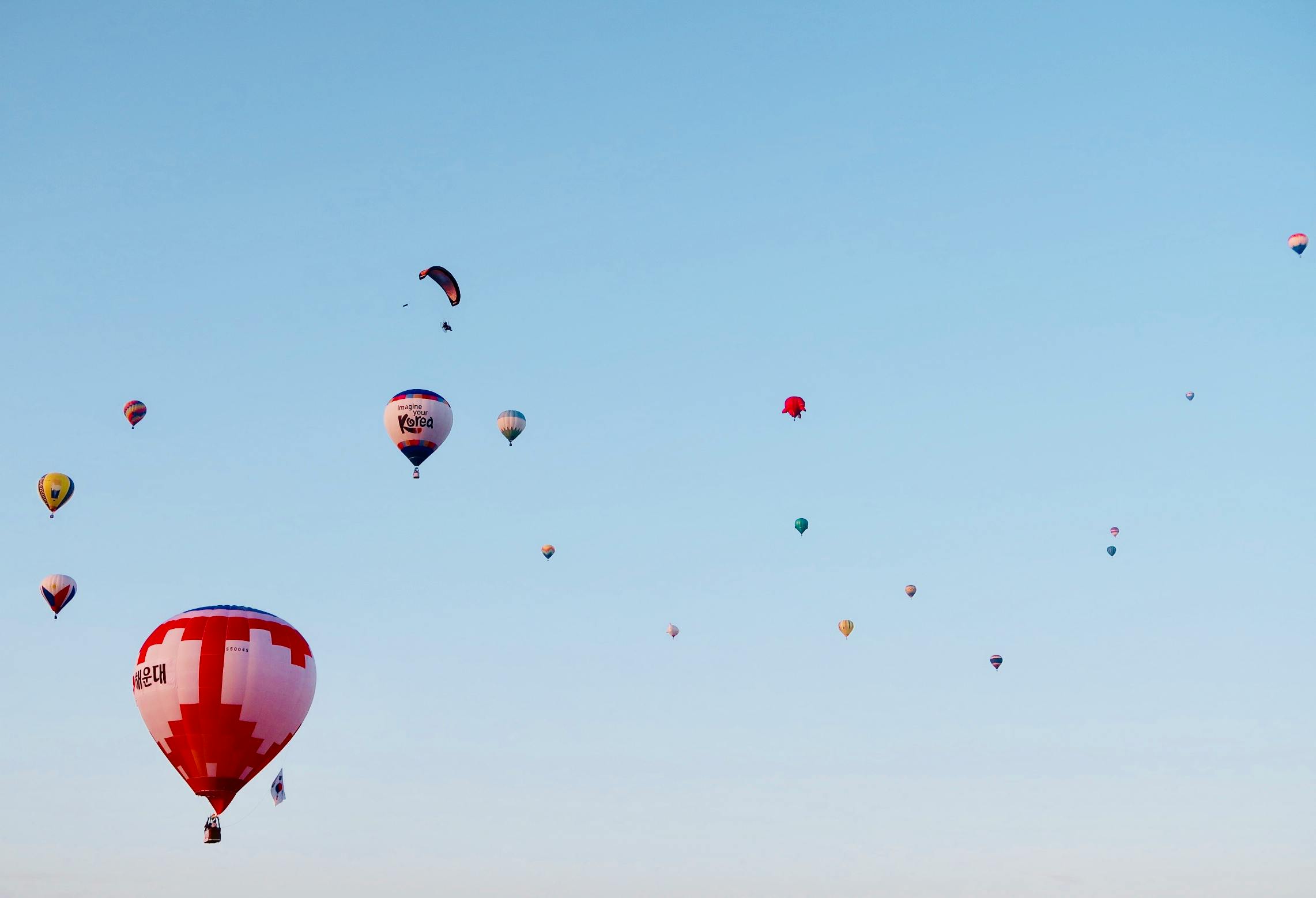 a bunch of hot air balloons flying in the sky, a photo, pexels contest winner, figuration libre, cloudless sky, red sky blue, ignant, many small details