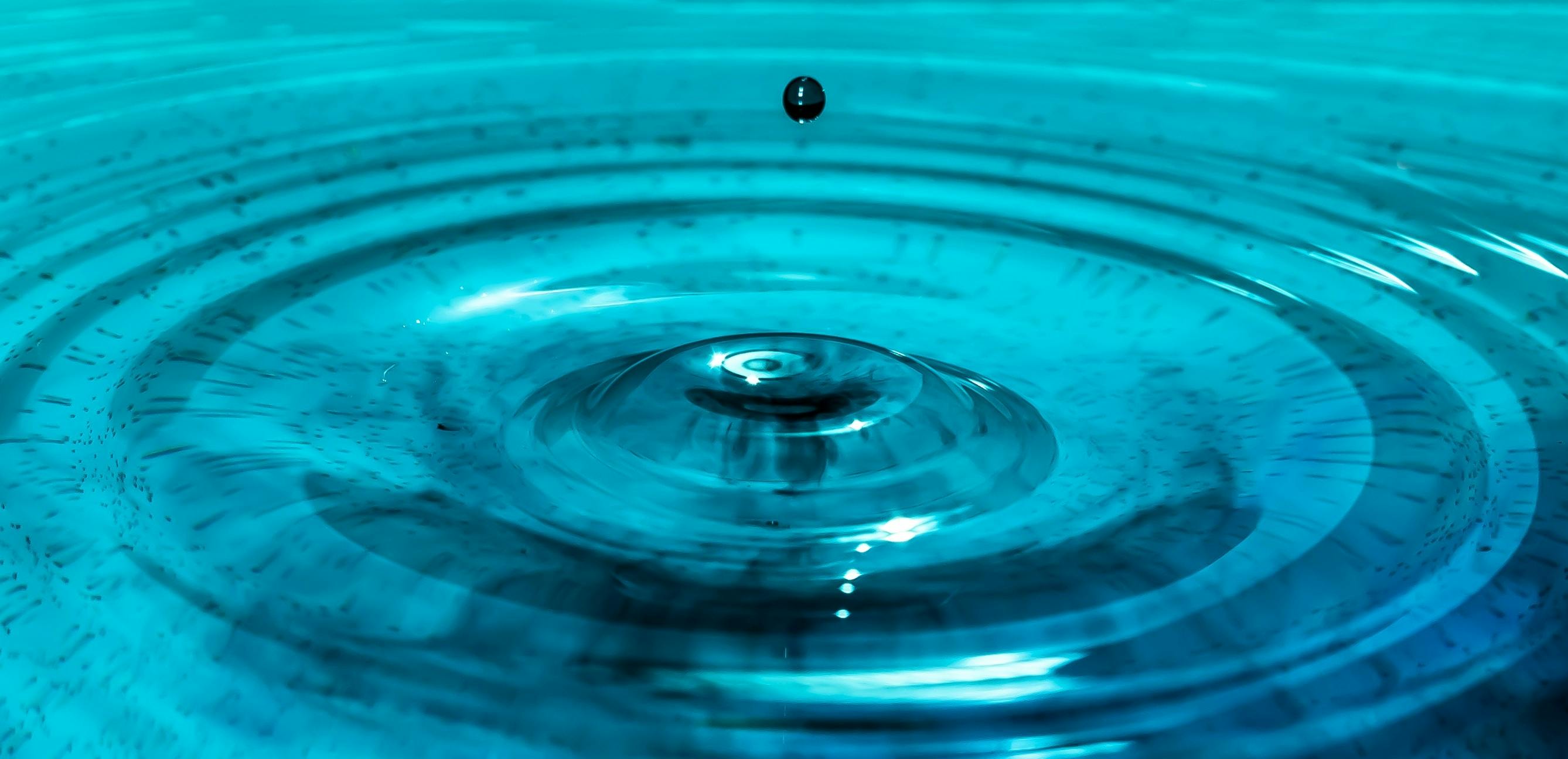 a close up of a water drop in a pool, teal energy, rippling electromagnetic, water gushing from ceiling, sapphire waters below