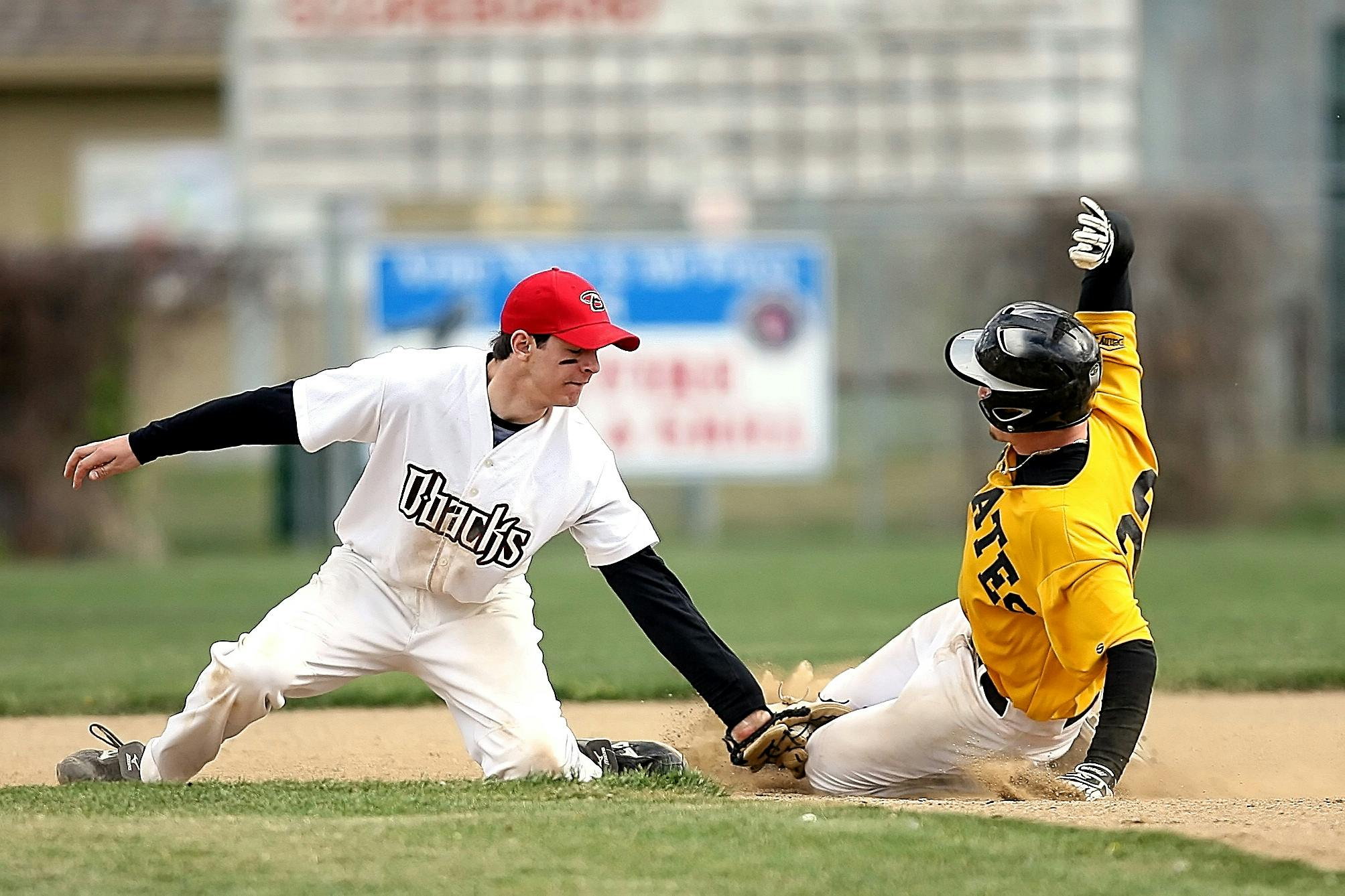 a couple of men playing a game of baseball, black and yellow and red scheme, professional photo, image, schools