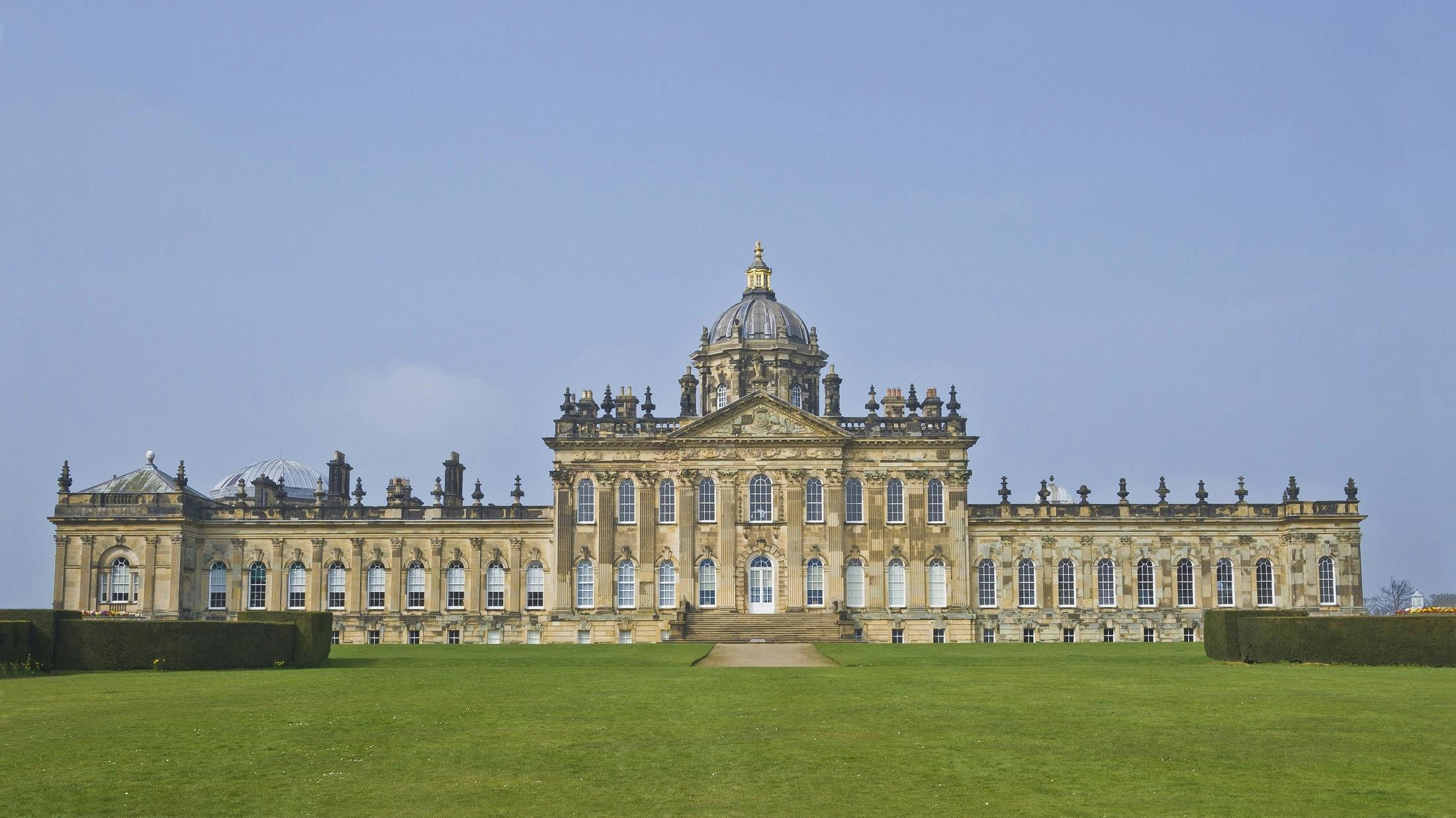 a large building sitting on top of a lush green field, inspired by Christopher Wren, baroque, the iron lady, exterior, yorkshire, facing front