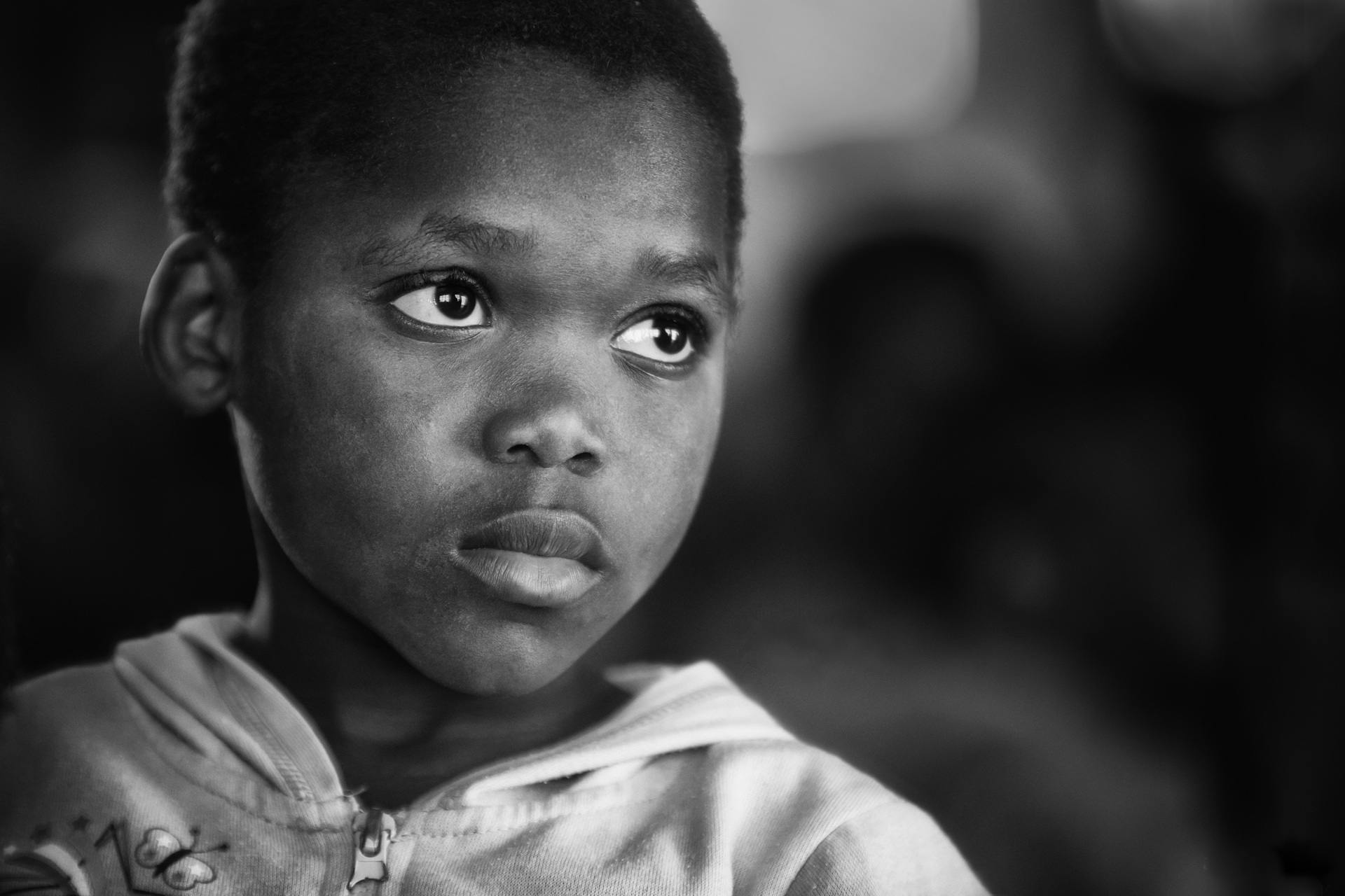 a black and white photo of a young boy, by Daniel Gelon, emmanuel shiru, gentle expression, she has a distant expression, screensaver