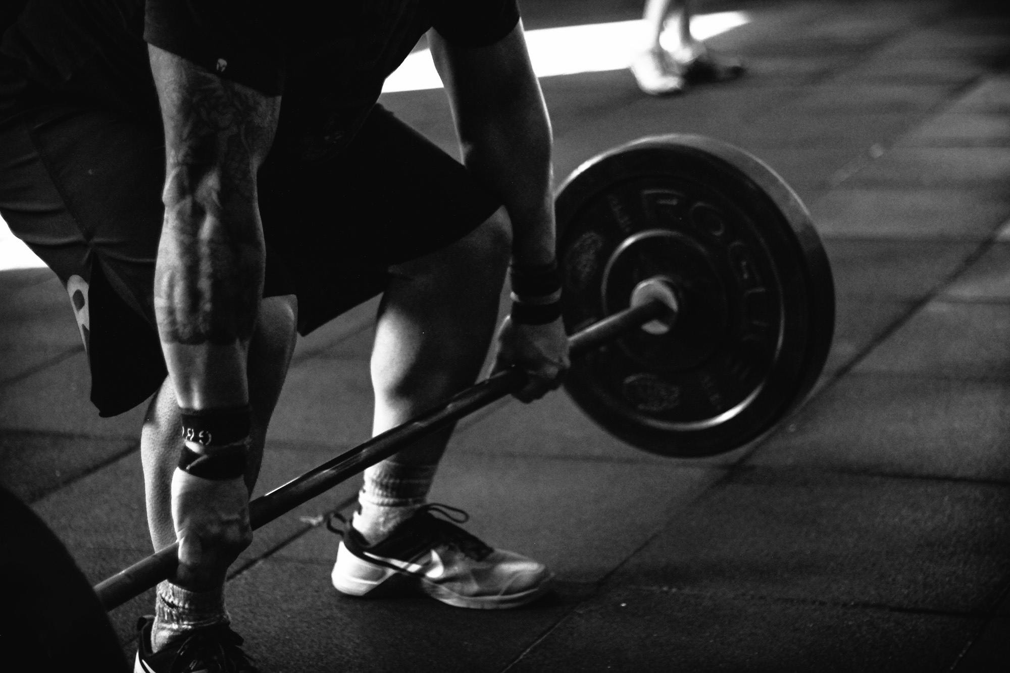 a black and white photo of a man lifting a barbell, grayscale photography, sneaker photo, gif, video footage