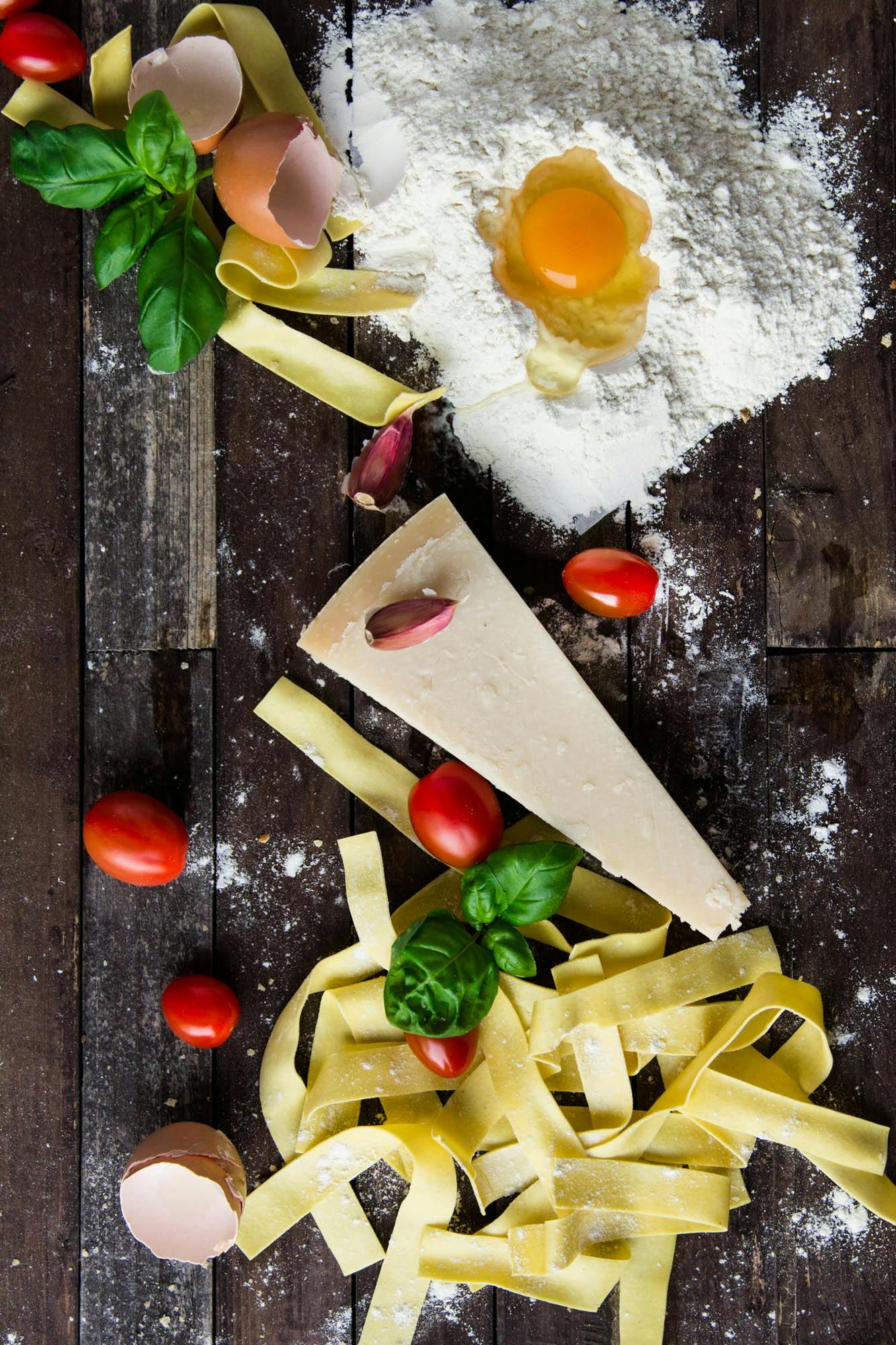 a wooden table topped with pasta and vegetables, a picture, by Carlo Martini, shutterstock contest winner, dessert, risographic, promotional image, close - up photograph
