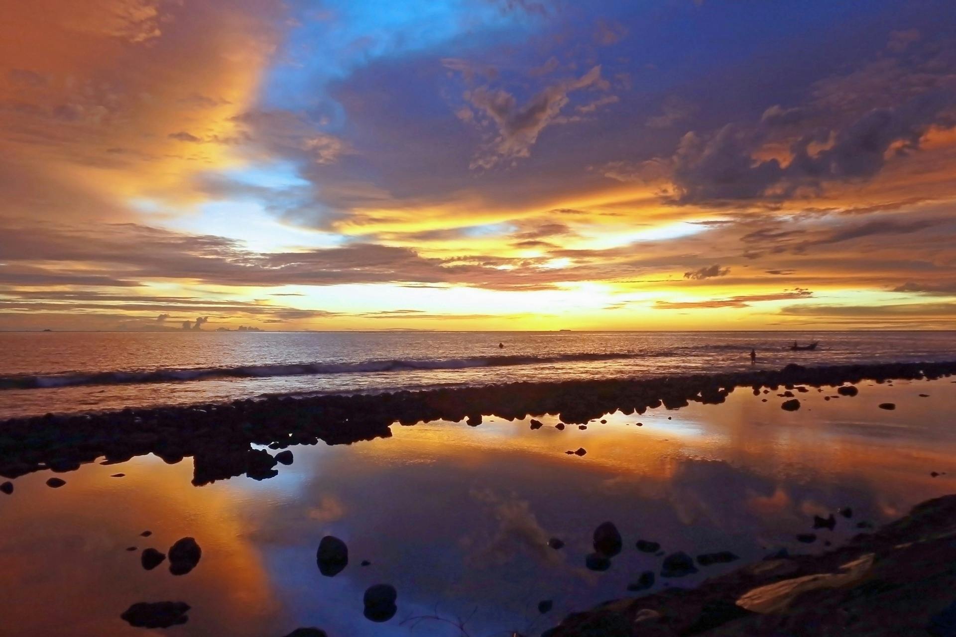 a large body of water sitting on top of a sandy beach, a picture, during a sunset, skies, reunion island, video