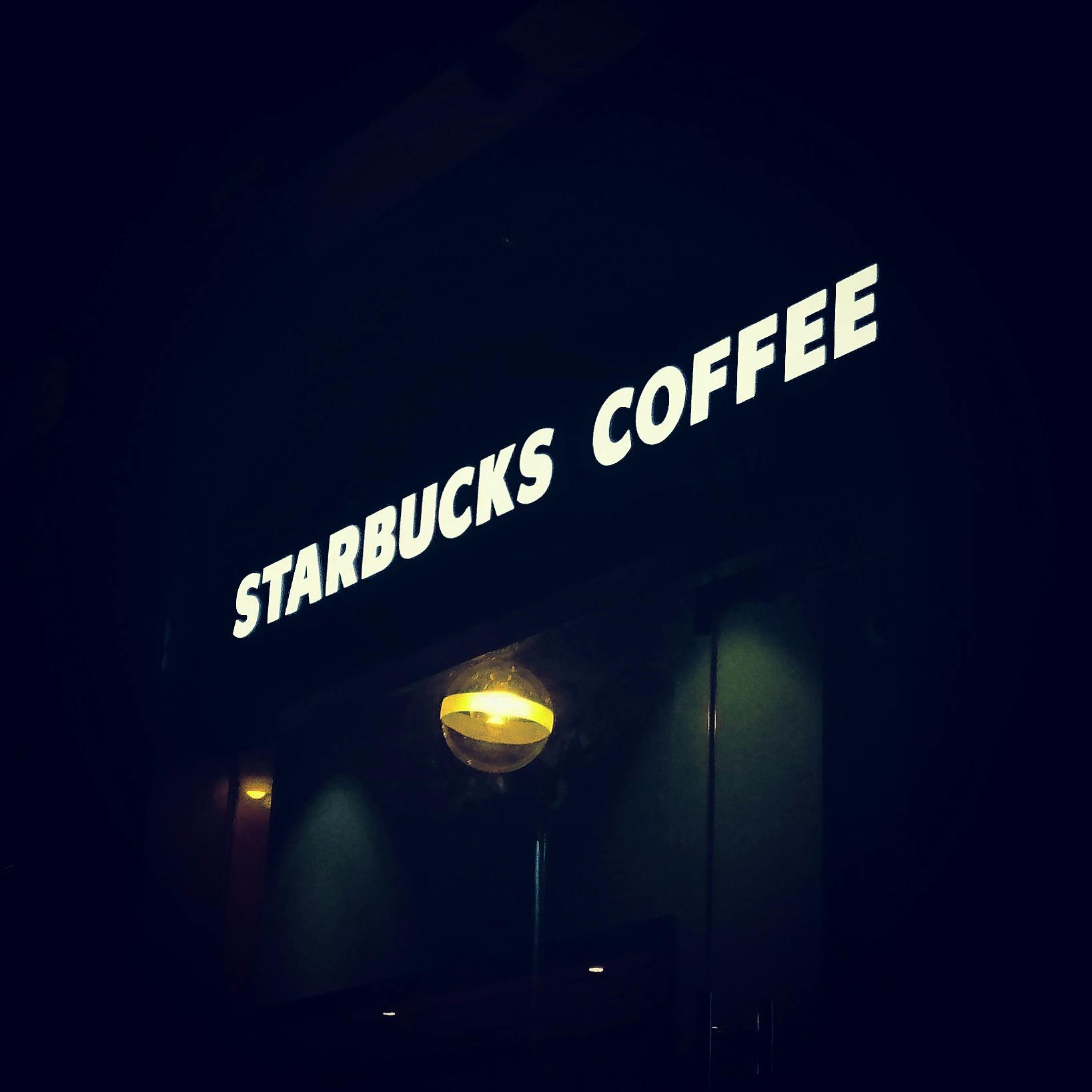 a starbucks sign lit up in the dark, a photo, trending on unsplash, 2 0 0 0's photo, iphone photo, arabica style, jets