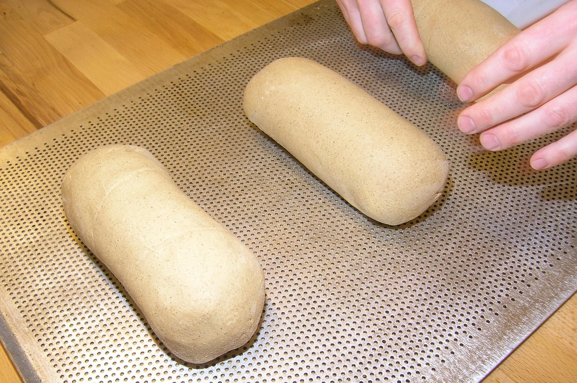 a close up of two doughnuts on a pan, inspired by Sarah Lucas, creating a thin monolith, wikihow, steamed buns, hand made