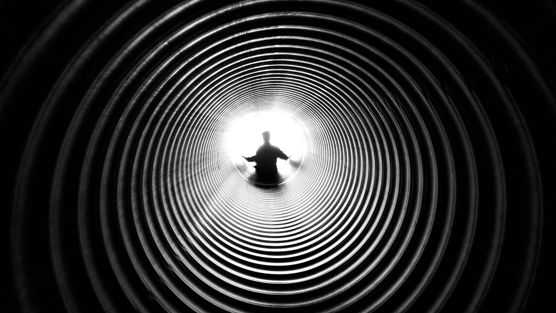 a black and white photo of a person in a tunnel, a black and white photo, by Matt Stewart, pexels contest winner, circles, water pipe, photo taken with an iphone, tubular creature