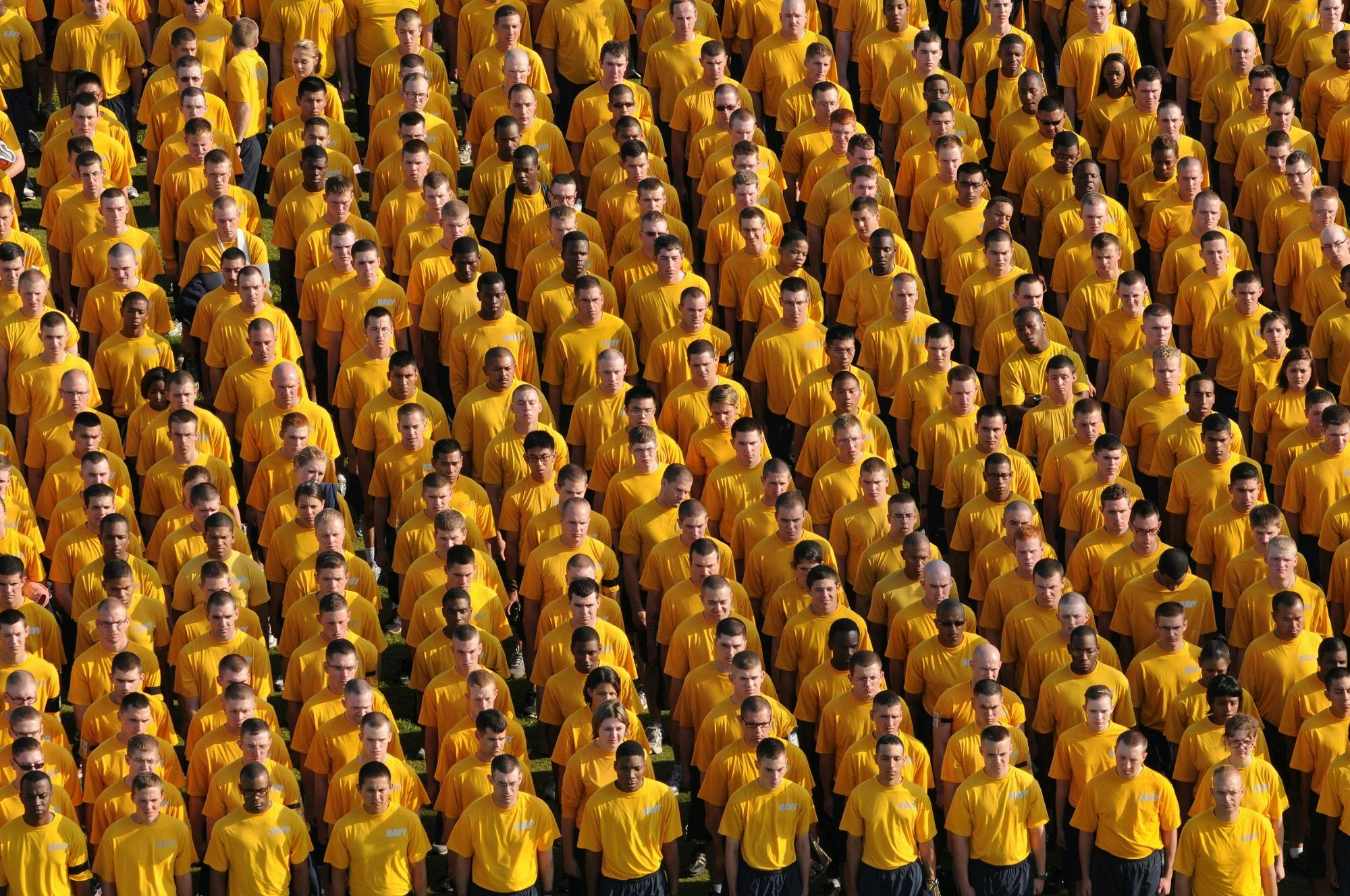 a group of people wearing yellow shirts standing around