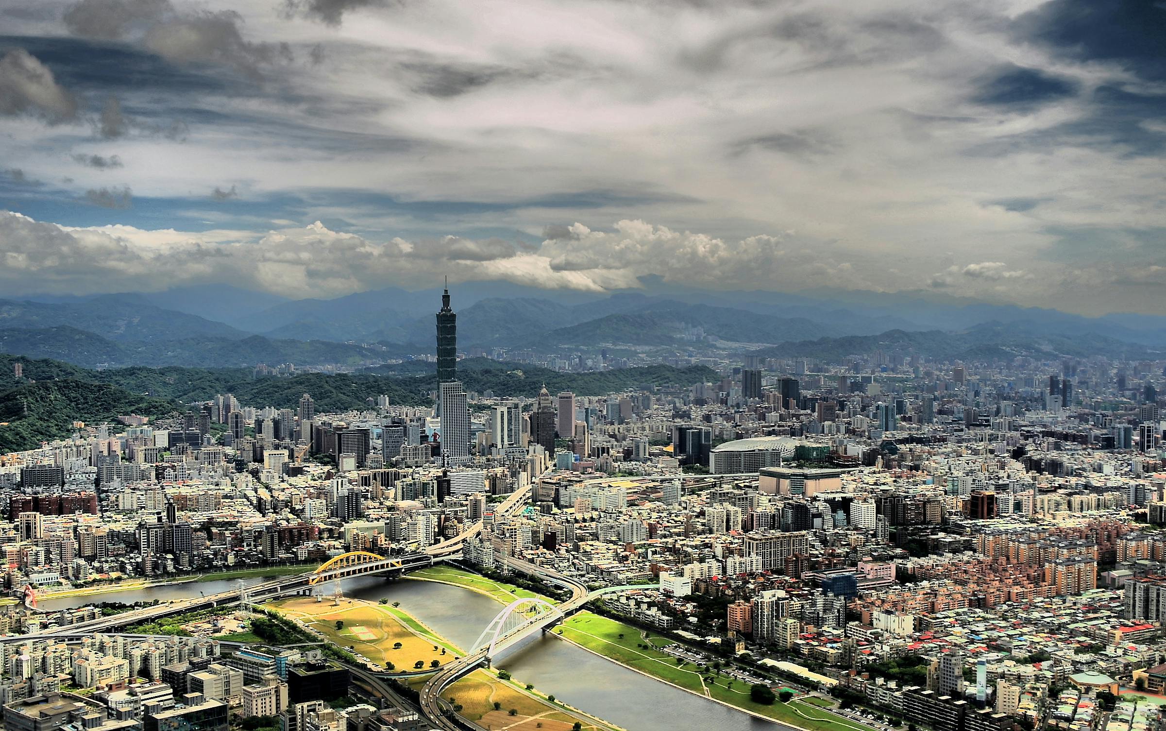 an aerial view of cityscape with mountains and river