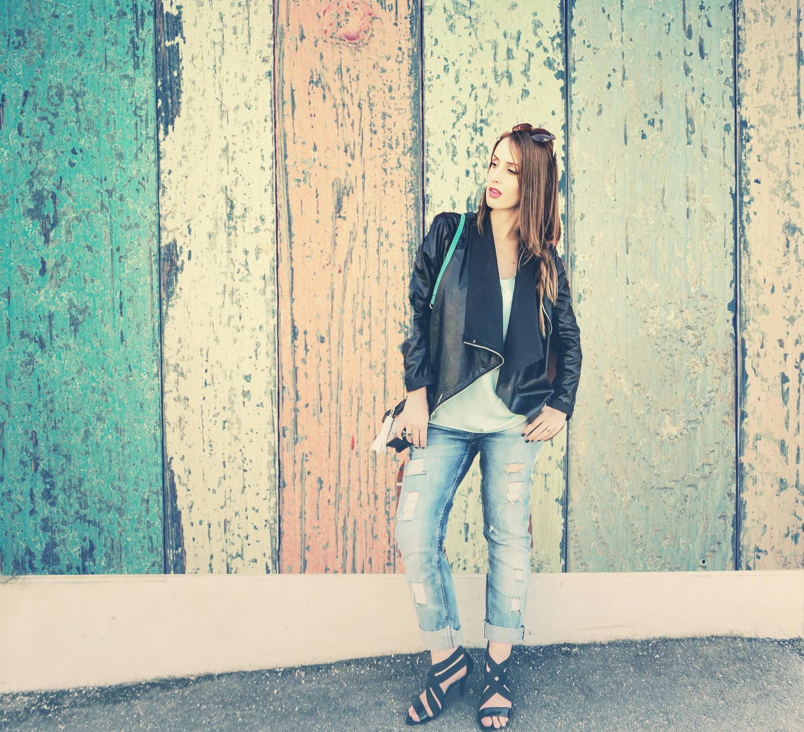 girl standing in front of wooden wall holding camera