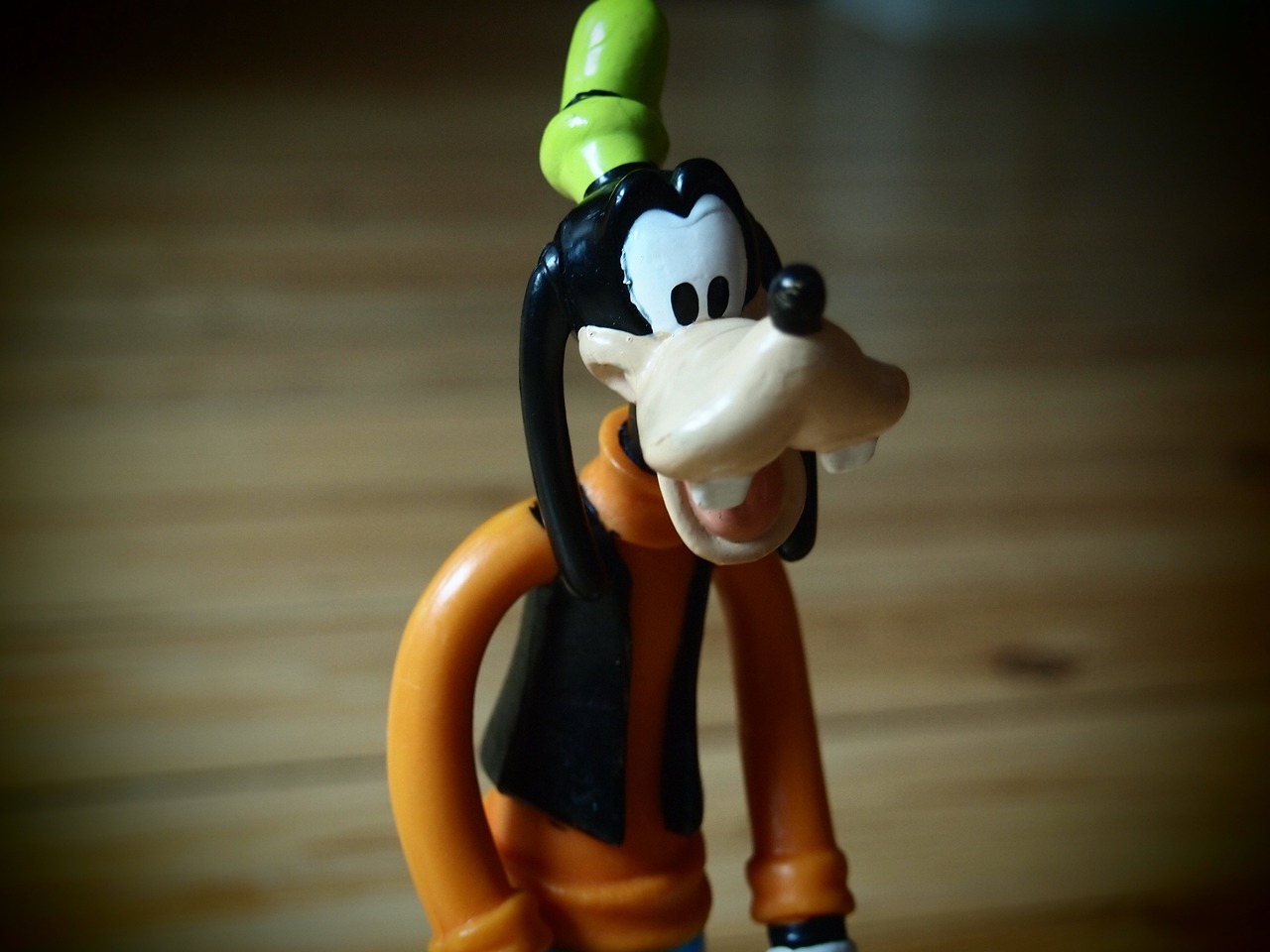 a close up of a toy on a table, inspired by Tex Avery, flickr, cobra, daffy duck, round teeth and goofy face, wearing green tophat, pluto