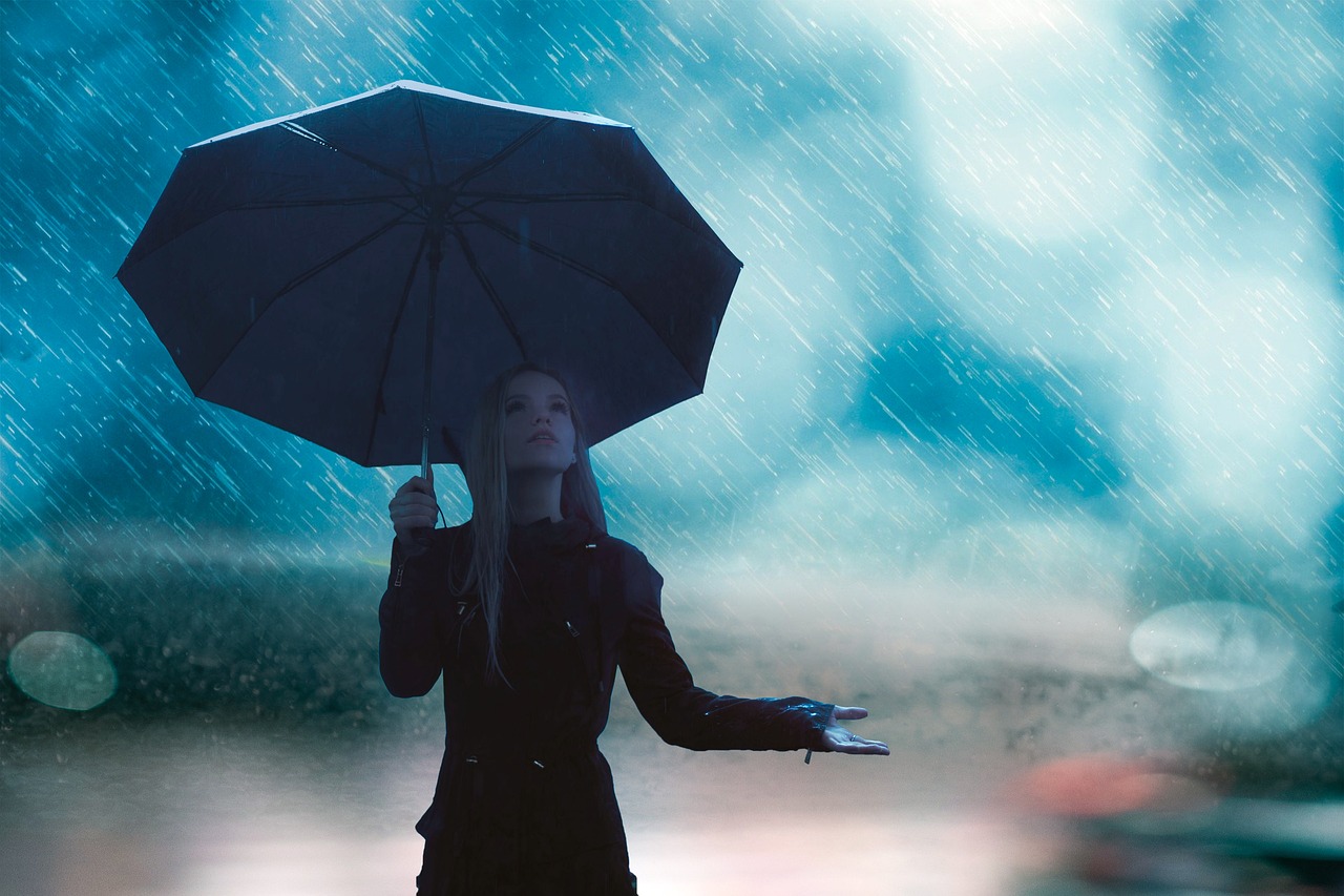 a woman holding an umbrella in the rain, pixabay, romanticism, blue mood, photorealistic photography, still from a music video, istockphoto