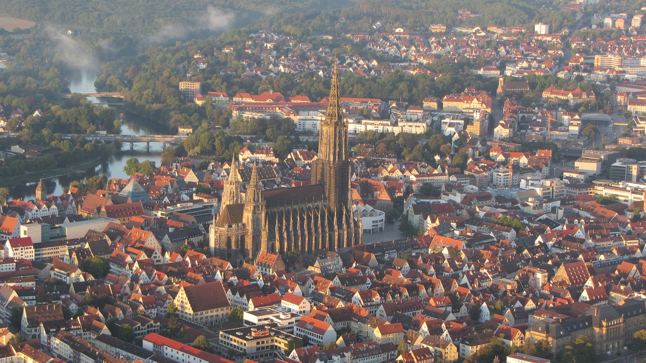 a view of a city from a bird's eye view, by Juergen von Huendeberg, cathedral of sun, brown, in the early morning, wikipedia