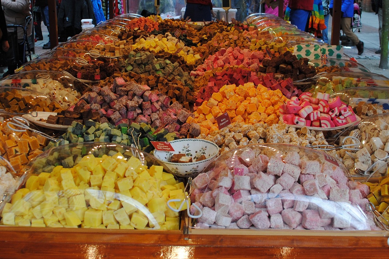 a table topped with lots of different types of candies, flickr, hurufiyya, wet market street, cubes, colorful”