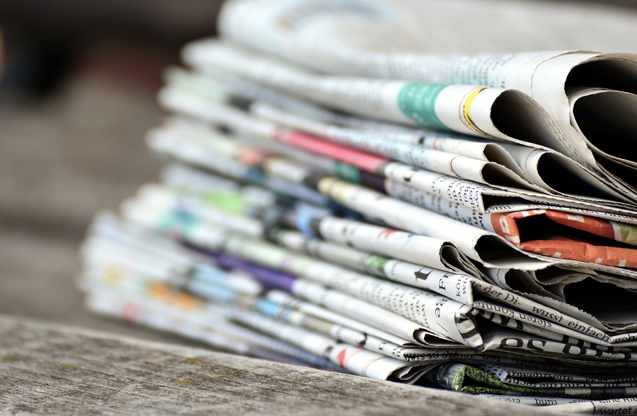 a stack of newspapers sitting on top of a wooden table, a picture, pexels, private press, round-cropped, 1128x191 resolution, children's, 3d with depth of field