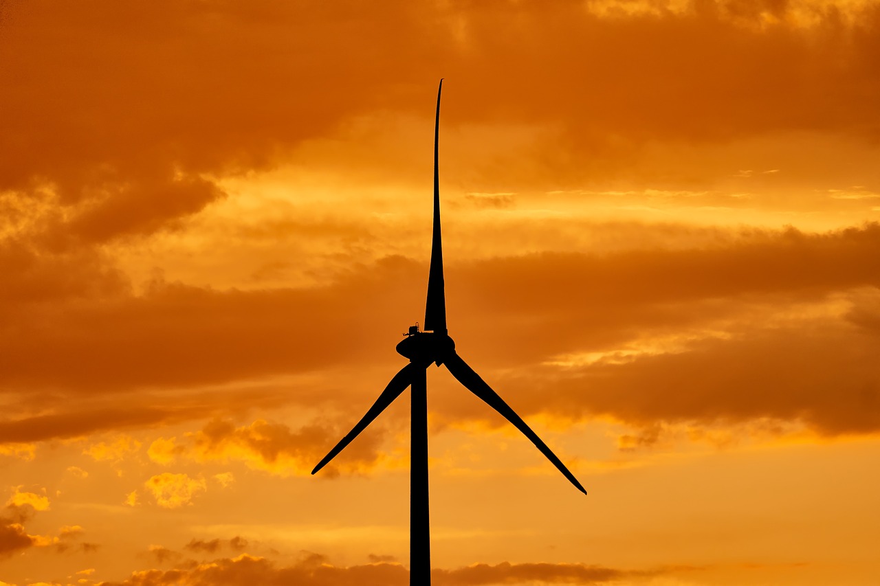 a wind turbine is silhouetted against an orange sky, a picture, by Hans Schwarz, shutterstock, low angle 8k hd nature photo, highly detailed product photo, striking pose, istockphoto